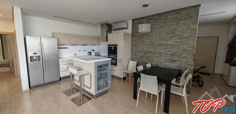 Küche in einer 3-Zimmer-Wohnung mit Holzboden und Esstisch.