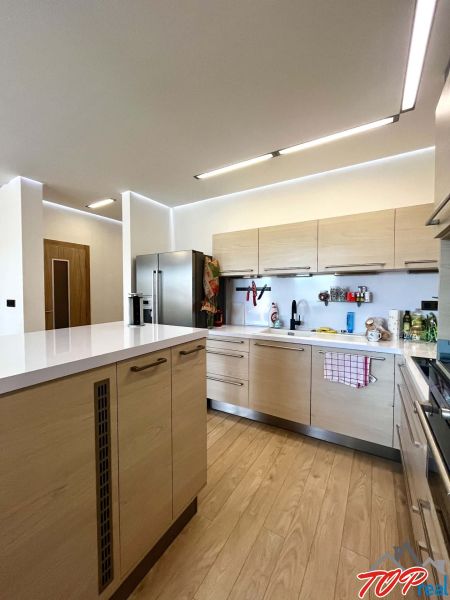 Die Küche einer 3-Zimmer-Wohnung mit einem Holzboden und hellen Möbeln.