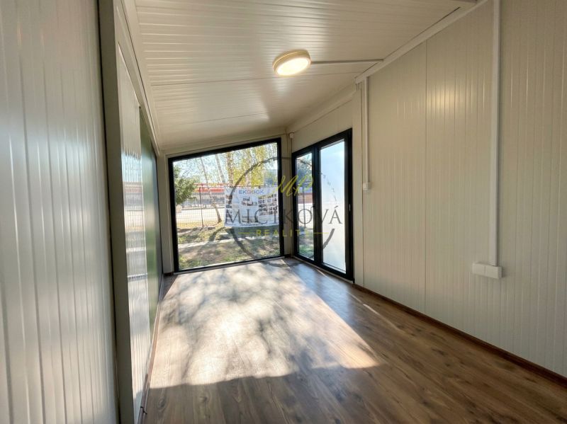 Innenraum mit verglasten Wänden und Boden in Holzoptik, Besondere Immobilien.