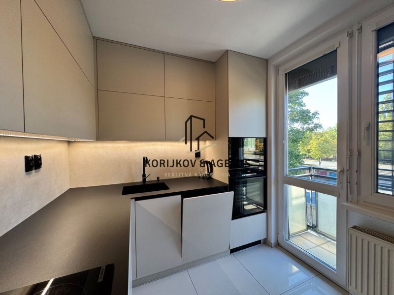 Küche in einer 3-Zimmer-Wohnung mit moderner Küchenzeile, eingebauten Geräten und großem Fenster.