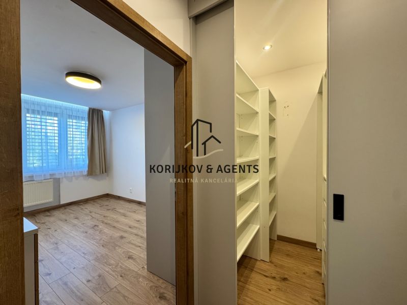 Ein Zimmer und ein Kleiderschrank in einer 3-Zimmer-Wohnung mit einem Boden in Holzoptik.