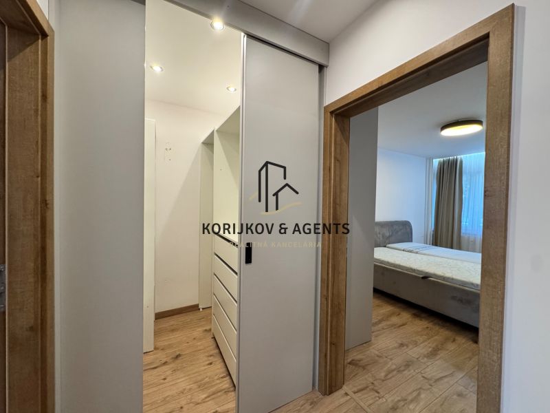 Flur mit Schiebetüren und Bett, Boden mit Holzdekor in einer 3-Zimmer-Wohnung.