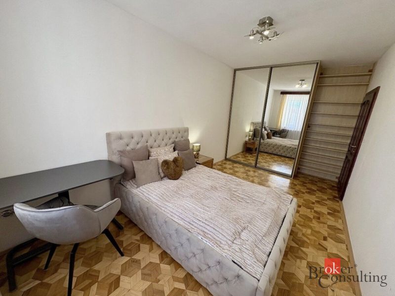 Schlafzimmer in einer 3-Zimmer-Wohnung mit Bett, Kleiderschrank und Holzboden.