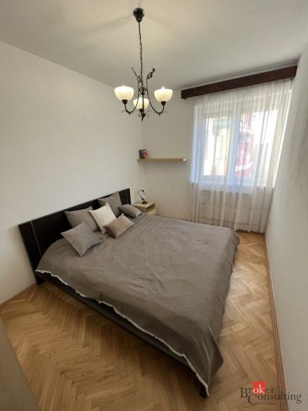 Schlafzimmer mit Doppelbett und Holzboden in einer 3-Zimmer-Wohnung.