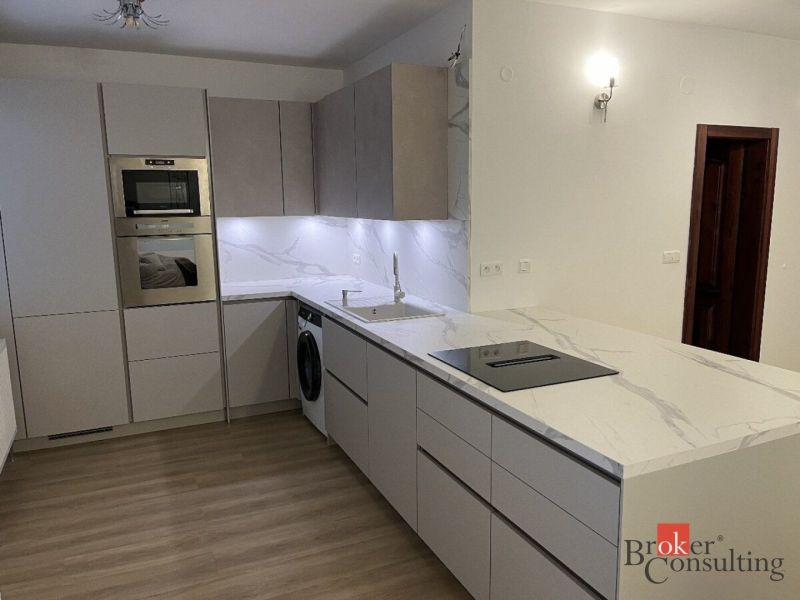 Küche in einer 3-Zimmer-Wohnung mit Marmor-Arbeitsplatte und Boden in Holzoptik.