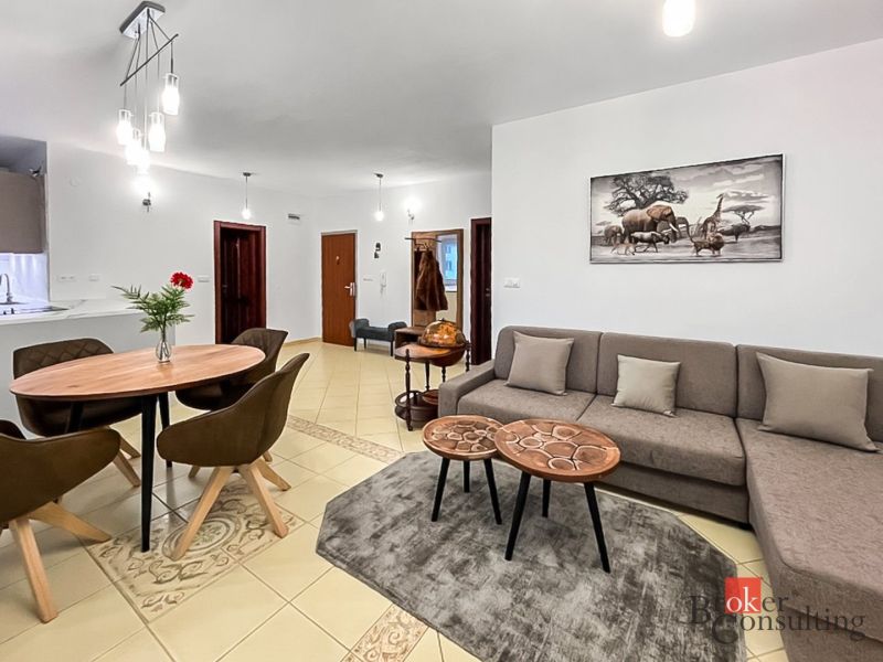 Wohnzimmer in einer 3-Zimmer-Wohnung mit einem bequemen Sofa und einem dekorativen Bild an der Wand.