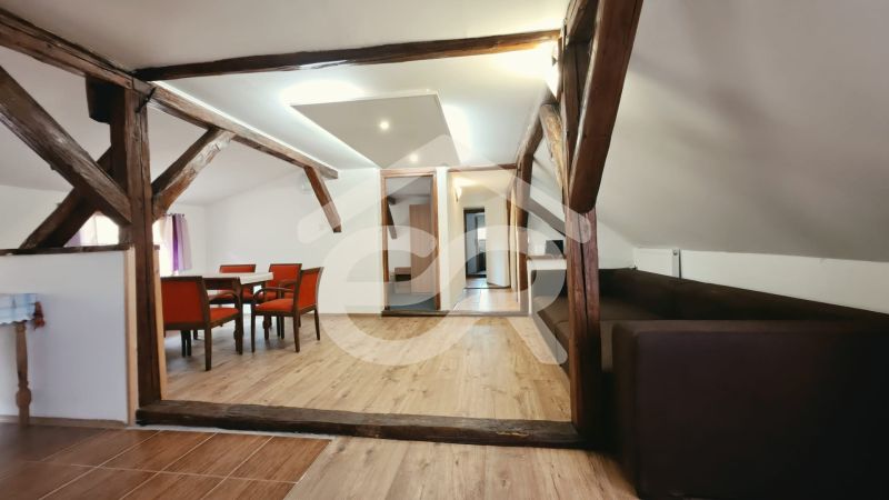 Ferienwohnung mit Holzboden, Holzbalken und bequemen Möbeln.