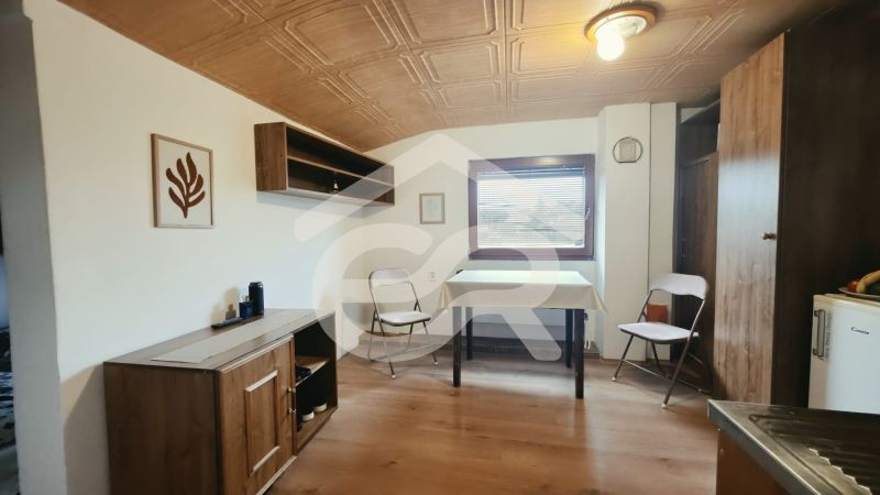 Innenraum einer Ferienwohnung mit Holzmöbeldekor und Klappstühlen.