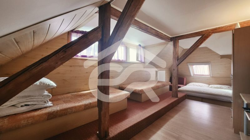 Dachzimmer in einer Ferienwohnung mit Holzboden und Betten.