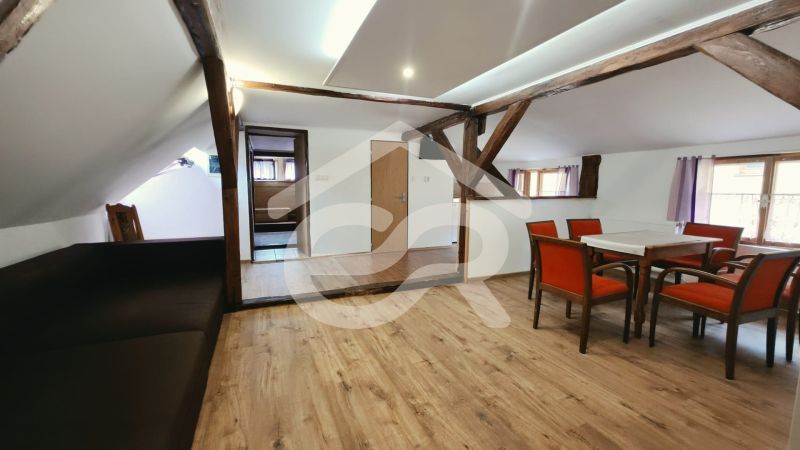 Eine Ferienwohnung mit Holzbalken und einem Boden in Holzoptik bietet einen Essbereich.