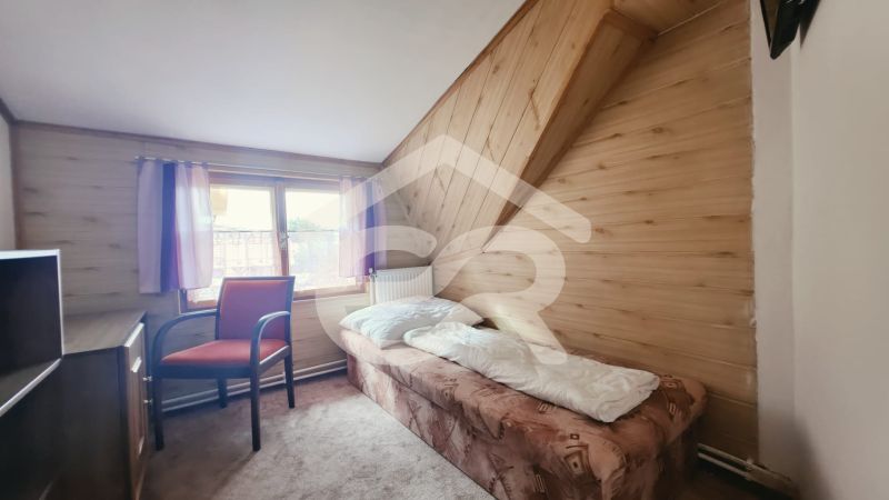Einzelzimmer im Ferienapartment mit Holzboden und Fenster.