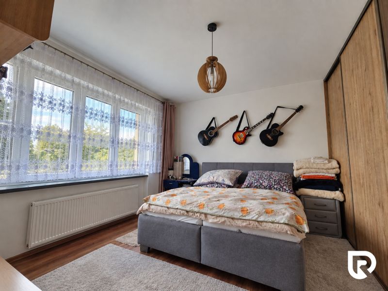 Schlafzimmer in einem Einfamilienhaus mit Gitarren an der Wand, Boden mit Holzdekor.