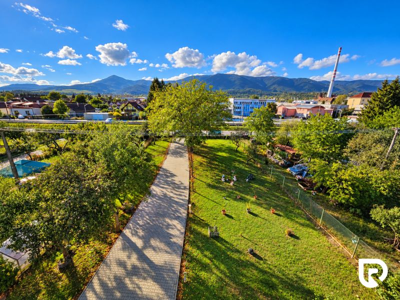 Blick auf den geräumigen Garten eines Einfamilienhauses in Martin mit Blick auf die Berge.