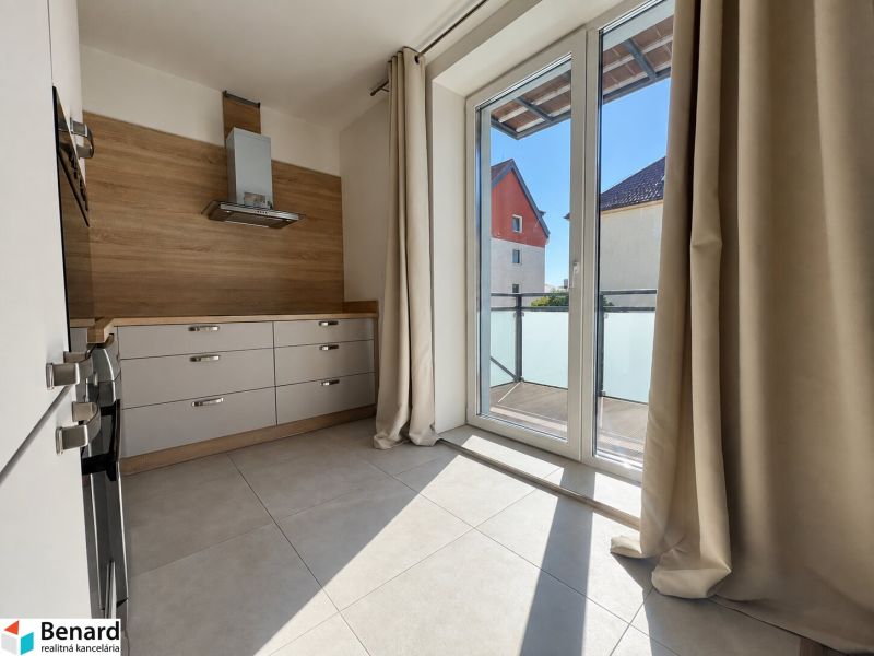 Küche in einer 2-Zimmer-Wohnung mit Fliesenboden und großen Fenstern.