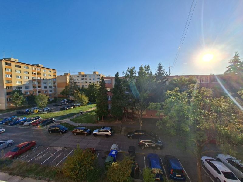 Autos parken in der Benedikt-Straße in Prievidza bei einem Einzimmerapartment, sonniger Tag.