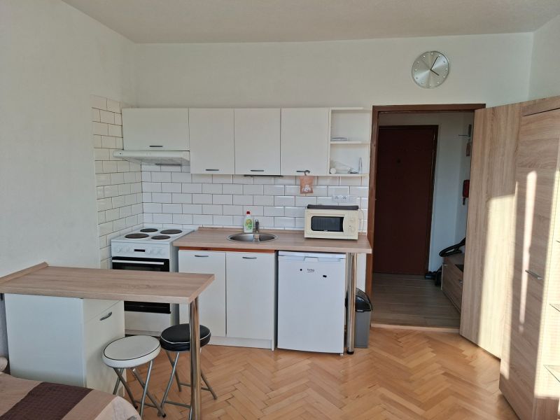 Küchenecke mit Holzboden in einem Einzimmerapartment.