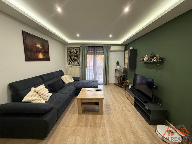 Wohnzimmer in einer Zweizimmerwohnung mit Holzboden und Sofa.