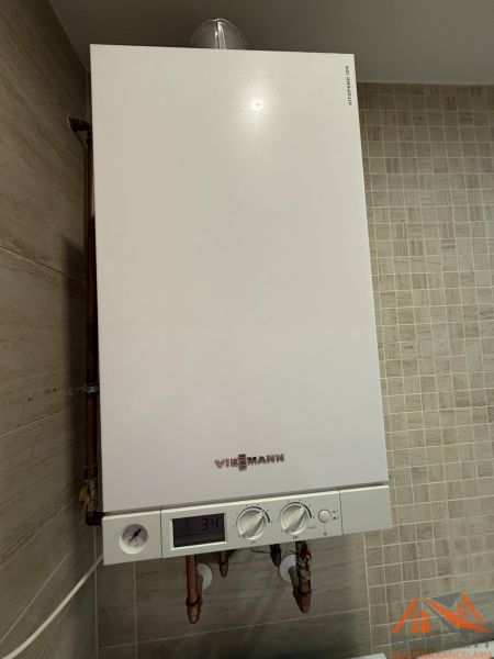 Kondensationskessel der Marke Viessmann im Innenraum einer 2-Zimmer-Wohnung auf beigen Fliesen.