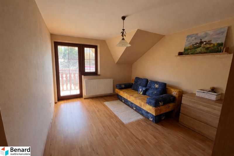 Ein Zimmerinterieur in einem Einfamilienhaus mit Holzboden und einem Sofa.
