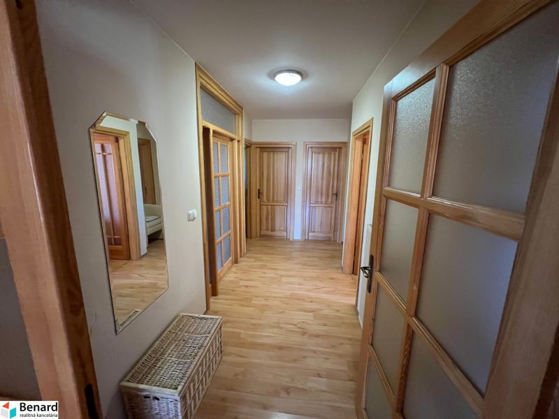 Der Flur in einem Einfamilienhaus mit einem Boden in Holzoptik und mehreren Türen.