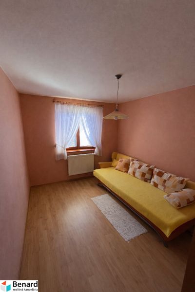 Ein Zimmer mit Holzboden-Dekor und einem Sofa in einem Einfamilienhaus.