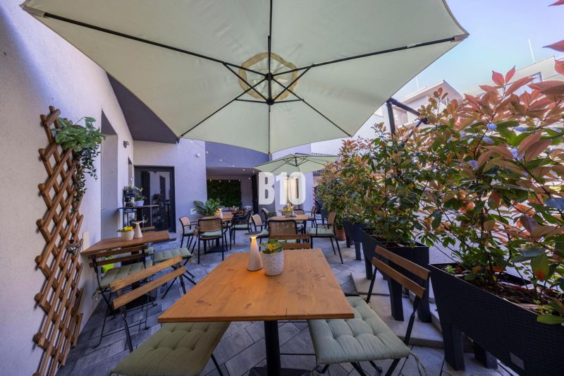 Eine eingerichtete Terrasse von Gastronomiebetrieben in Bratislava - Altstadt mit Sitzgelegenheiten und Sonnenschirmen.