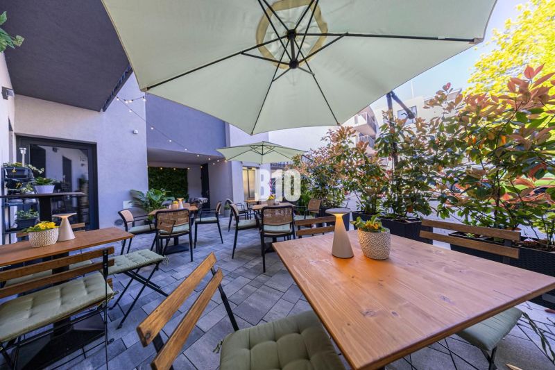 Außenbereiche der Gastronomie in Bratislava - Altstadt mit Holztischen und Sonnenschirmen.