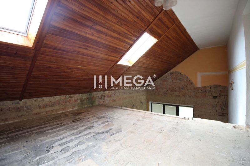 Das Dachgeschoss eines Einfamilienhauses mit Holz-Dachfenstern, Ziegelwand, Lichtschächte im Dach.