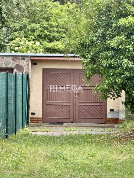Garagen in der Osloboditeľov-Straße in Humenné mit einem Holztor, umgeben von Grün.