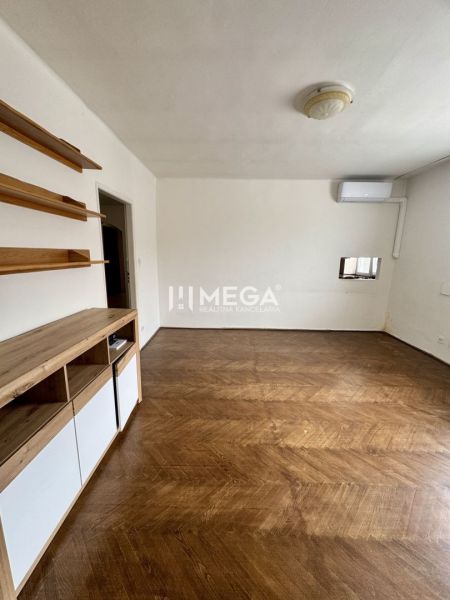 Ein Zimmer in einer 3-Zimmer-Wohnung mit einem Holzboden und Wandregalen.