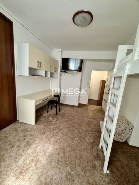 Ein Zimmer mit einem Schreibtisch und einem Hochbett in einer 3-Zimmer-Wohnung.