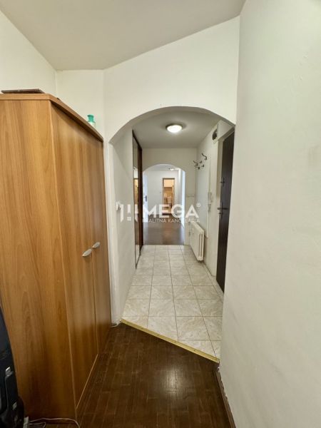Der Flur in der 3-Zimmer-Wohnung mit Fliesen und einem Boden in Holzoptik.