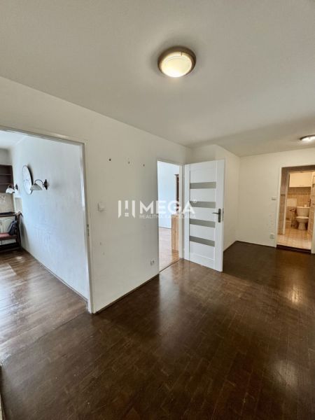 Flur mit Holzboden und Türen in einer 3-Zimmer-Wohnung.