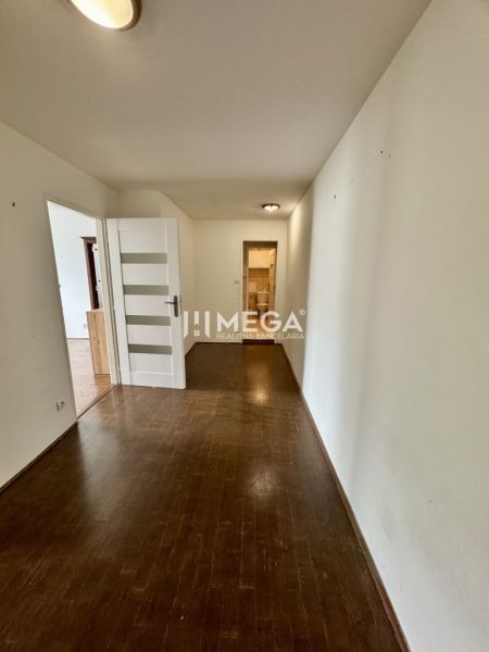 Der Flur in der 3-Zimmer-Wohnung mit weißen Türen und einem Boden in Holzoptik.