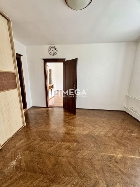 Ein Raum in einer 3-Zimmer-Wohnung mit einem Boden in Holzoptik und offenen Türen.