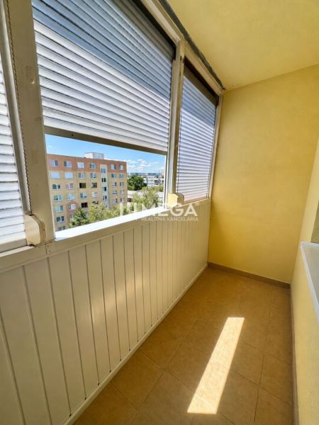 Ein verglaster Balkon mit Blick auf Wohnblöcke, Teil einer Einzimmerwohnung.