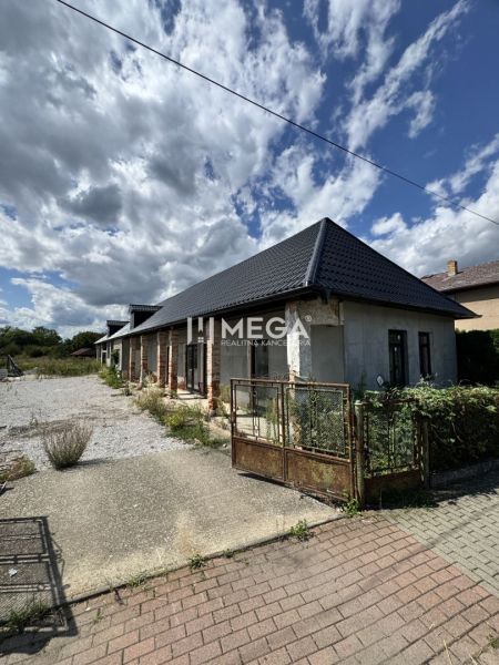 Ein Einfamilienhaus in Nacina Ves mit modernem Dach und einem weitläufigen offenen Grundstück.