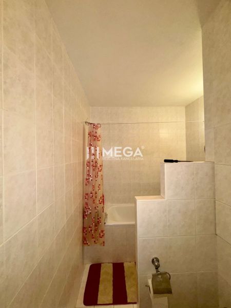 Badezimmer in einer 3-Zimmer-Wohnung mit Badewanne und einem auffälligen gemusterten Vorhang.