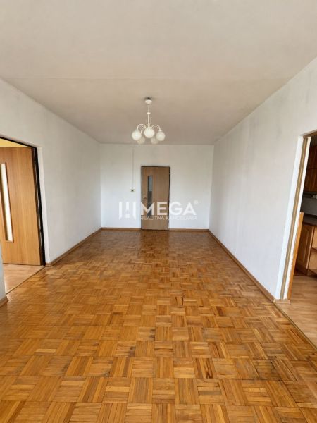 Wohnzimmer in einer 3-Zimmer-Wohnung mit Holzboden und Kronleuchter.