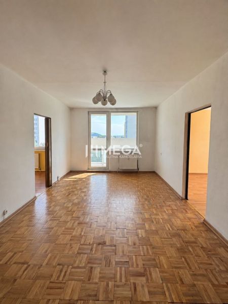 Ein Zimmer in einer 3-Zimmer-Wohnung mit einem Boden in Holzoptik und einer hängenden Leuchte.