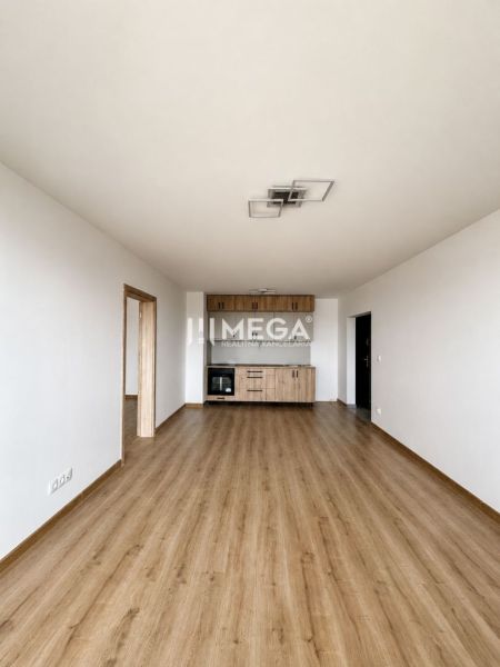 Wohnzimmer in einer 3-Zimmer-Wohnung mit Holzboden und Küchenzeile.