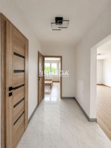 Flur in einer 3-Zimmer-Wohnung mit Holztüren und einem Boden in Holzoptik.