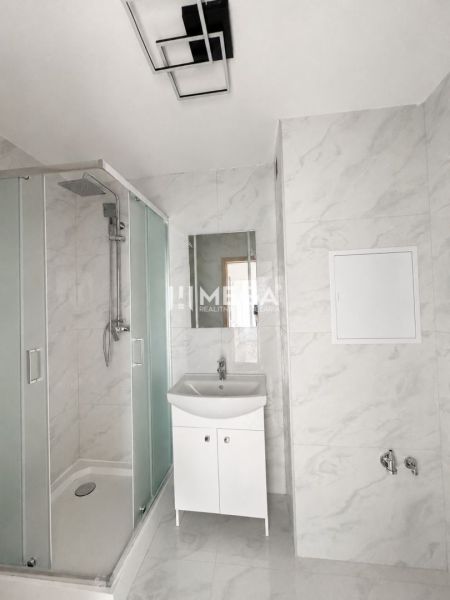 Badezimmer in einer 3-Zimmer-Wohnung mit moderner Duschkabine und weißem Waschbecken.