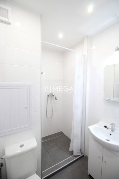 Badezimmer in einer Ferienwohnung mit Toilette, Dusche und Waschbecken.