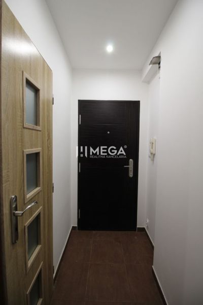 Eingang zum Ferienapartment mit hellen Wänden und Türen in Holzoptik.