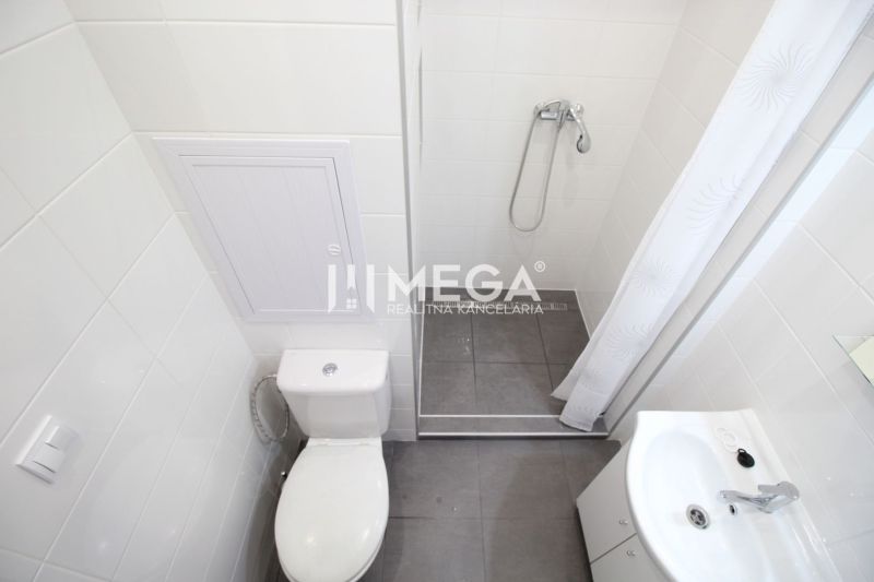 Badezimmer in einer Ferienwohnung mit Toilette, Dusche und Waschbecken.
