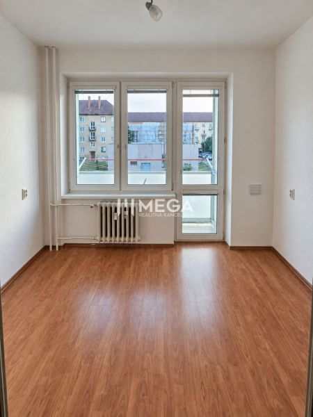 Ein Zimmer in einer 2-Zimmer-Wohnung mit einem Holzboden und einem großen Fenster.