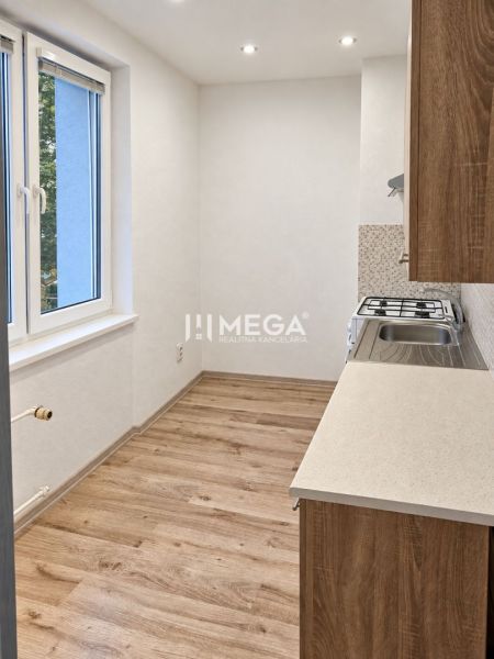 Küche in einer 2-Zimmer-Wohnung mit Holzboden und Fenster.