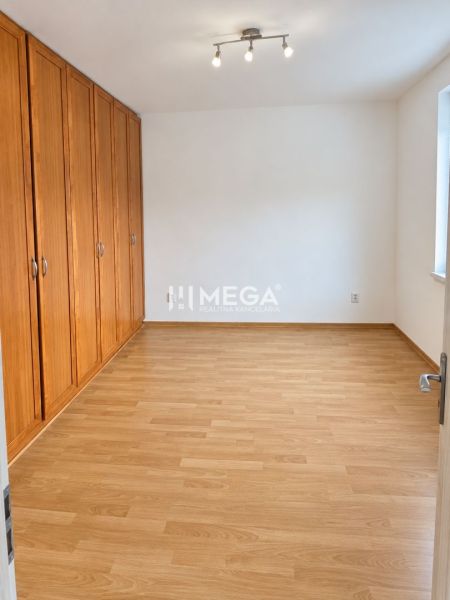 Schlafzimmer in einer 2-Zimmer-Wohnung mit Holzboden und Einbauschränken.