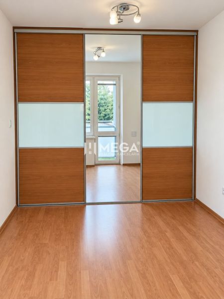 Boden mit Holzdekor, Einbauschrank und Leuchte in einer 2-Zimmer-Wohnung.